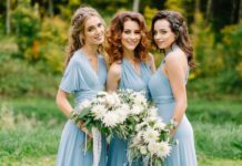 Three bridesmaids in pale blue dresses holding white flower bouquets