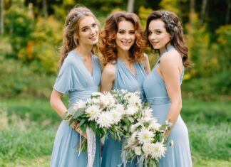 Three bridesmaids in pale blue dresses holding white flower bouquets