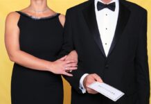 Two formally dressed guests holding an invitation