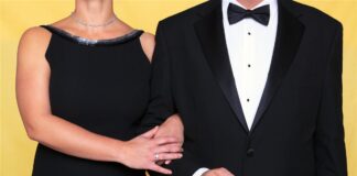 Two formally dressed guests holding an invitation